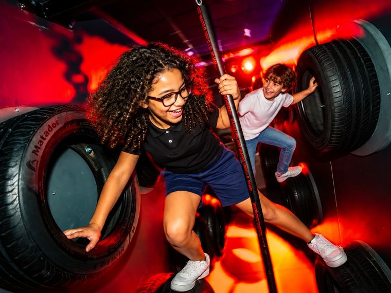 Deux enfants franchissent un parcours de pneus suspendus à Cube Challenges