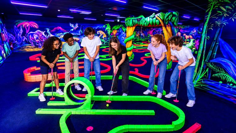 Six enfants autour du trou à looping du mini-golf fluo Goolfy