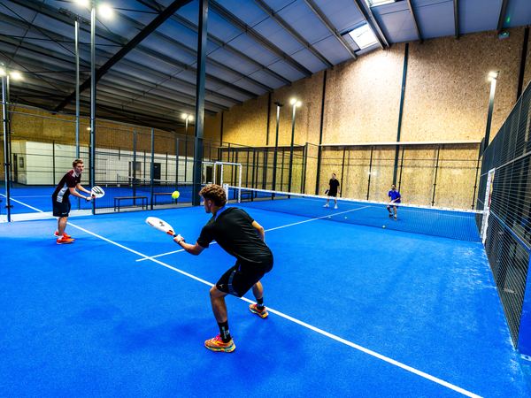 Joueurs sur une piste de padel couverte