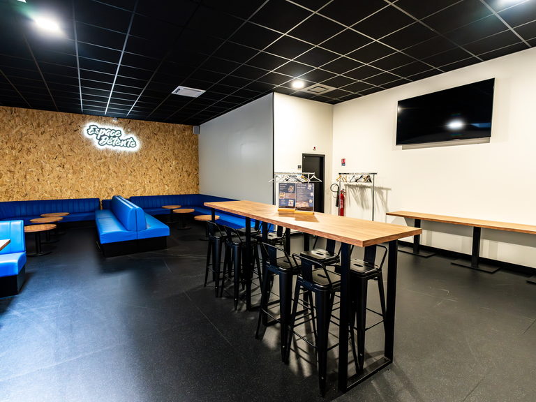 Espace détente privatisé avec banquettes et mange-debouts, séminaire chez Game Parc
