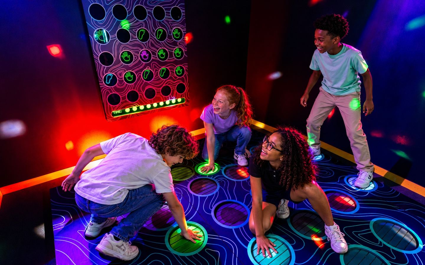 Quatre enfants relèvent un défi sur un sol lumineux à Cube Challenges, chez Game Parc à Poitiers