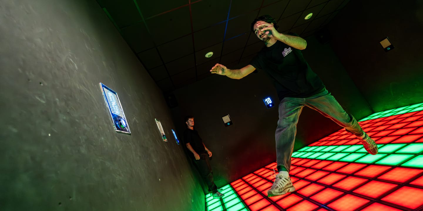 Joueur qui bondit sur les dalles LED rouges et vertes, Pulse UP, Game Parc Poitiers
